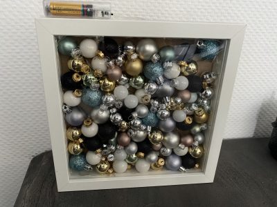 DIY Bilderrahmen gefüllt mit Weihnachtskugeln und einer Lichterkette