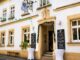 Traditionelles Wirtshaus Münchner Hofbräu in Coburg mit festlich geschmückter Fassade und Stehtischen